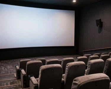 Interior of a modern screening room with a large screen and comfortable chairs, dark color palette, sophisticated lighting.
