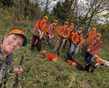 Group of women posing with dogs after a pheasant hunt.