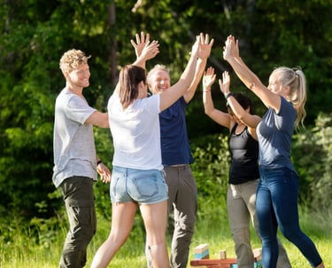 Team high-fiving and celebrating after winning a challenge during a team-building retreat