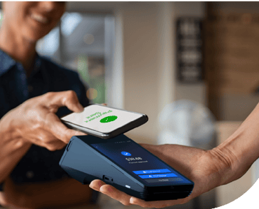 Customer making a contactless mobile payment with a smartphone at a credit card terminal.