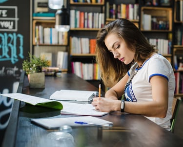 Autora trabajando en su obra en una biblioteca, imagen representativa de autores y editoriales