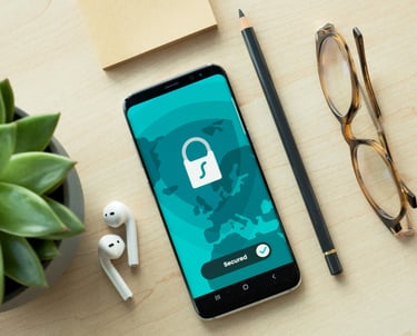 Picture of a phone, pencil, glasses, headphones and plant on a desk