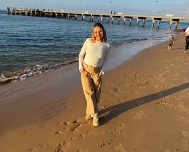 Una mujer caminando al lado de una playa 