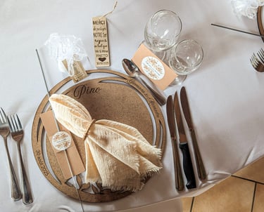 Rustic wedding table setting with personalized wooden placemat, linen napkin, and elegant silverware.