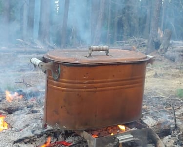 A vintage copper boiler pot used for natural dying in the forest.