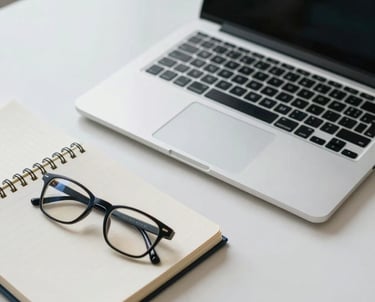 A high-angle view of a professional desk with a laptop, a notebook, and a pair of glasses. The palette is professional and calm with navy and off-white tones.
