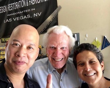 Three smiling men posing in a Las Vegas custom fabrication and restoration workshop.