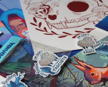 Prints and sticker scattered. Illustrations featuring animal, nature and social justice themes.