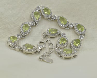 Elegant silver bracelet featuring teardrop-shaped green peridot gemstones and sparkling cz accents.