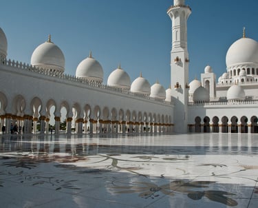 Las cúpulas y arcos de mármol blanco de la Gran Mezquita Sheikh Zayed en Abu Dabi, bajo un cielo azu