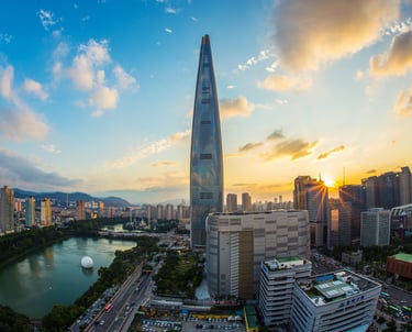 Puesta de sol sobre el horizonte de Seúl, con el rascacielos Lotte World Tower y el lago Seokchon 