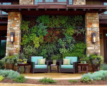 Modern outdoor patio featuring a lush vertical garden wall behind teal wicker lounge chairs.