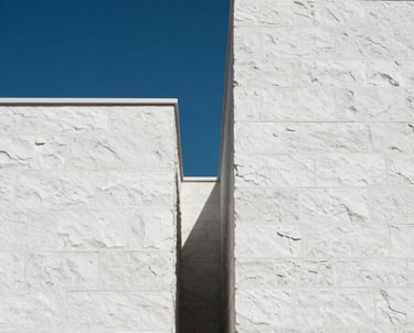 Clean, minimalist shot of architectural details in Bodrum: white stone walls against a deep blue sky. High contrast and modern. Turkish / Aegean Coast.