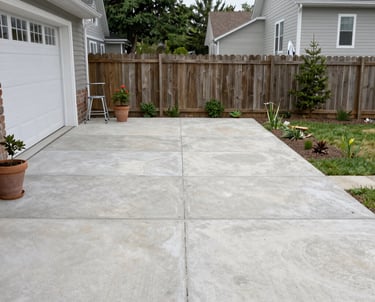 Newly completed modern concrete driveway with sharp lines and a smooth surface under natural daylight.