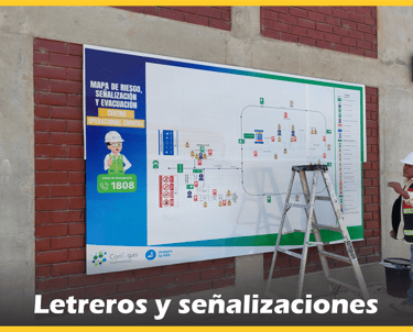 Mapa de riesgo y señalizaciones de seguridad industrial instalados en pared de ladrillo.