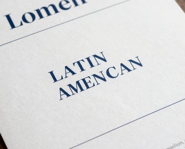 Clean, flat-lay of brand guidelines printed on premium paper. Sophisticated typography, deep blue and muted steel blue accents, Latin American / Hispanic design aesthetic.