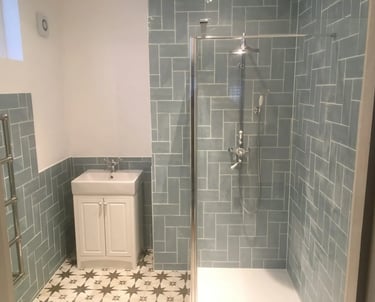 Modern bathroom renovation with walk-in shower and green wall tiles in Brighton home