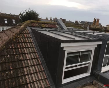 Loft conversion with dormer window added to roof of Brighton home.