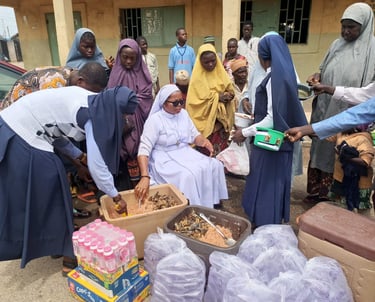 Catholic nuns and local community members distribute food and drinks during a charity relief event.