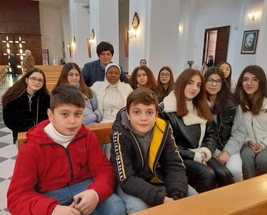 A diverse group of students sitting on wooden pews inside a cathedral for a school event.