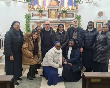A group of Catholic nuns and several men and women posing for a photo inside a church in front of the altar.