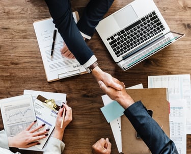 business people negotiating and shaking hands across the table