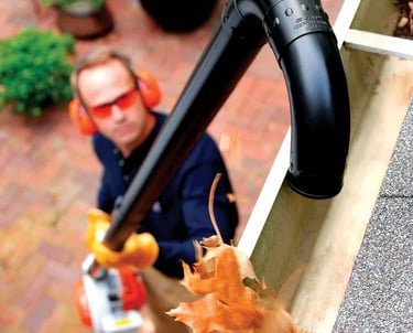 Professional gutter cleaning technician working on a residential home
