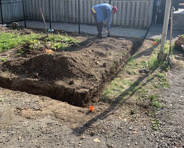 Manual excavation and soil preparation for a new garden bed or retaining wall footing.