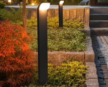 Modern LED path lights in a garden bed.