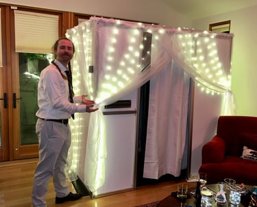 man standing next to wedding photobooth