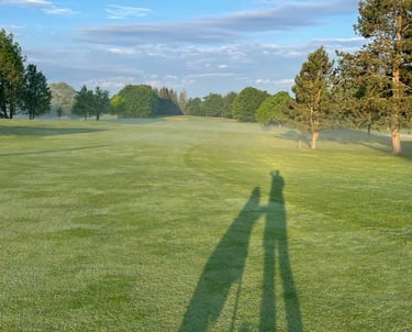 a person standing in a field with a golfbag
