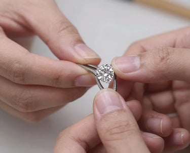 Close-up of a skilled artisan crafting a delicate gold necklace in a warm workshop.