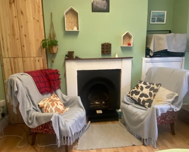 A photo of a  pair of armchairs around a fireplace