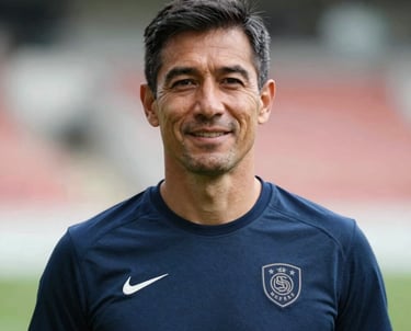 Professional headshot portrait of an experienced sports trainer man in athletic wear with a subtle national team crest, positive and professional demeanor, outdoor stadium background.
