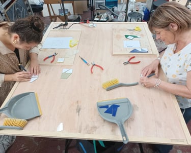 Cours de vitrail : table de travail, outils de découpe et verre à l'atelier.