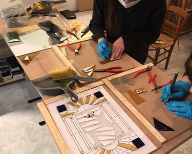 Initiation au vitrail : élève réalisant une coupe de verre sur-mesure.