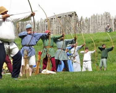 Medieval archers in line shooting their yew longbow