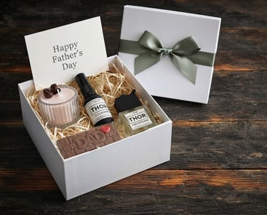 Luxury Father's Day gift box with cologne, diffuser, candle, and chocolate on a rustic wood surface.