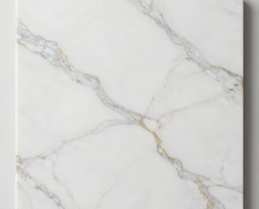 Close-up of polished white marble slabs with subtle gray veining stacked neatly in a sunlit warehouse.