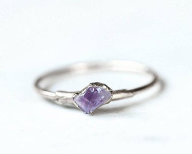 "Anillo de plata artesanal con una amatista en bruto, engastada en una montura minimalista de rama