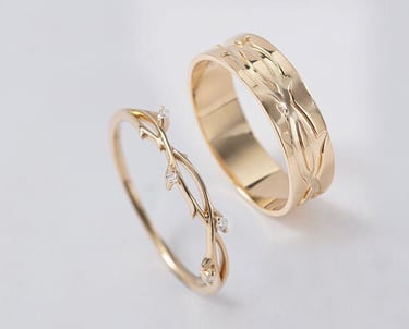 Elegantes alianzas de boda a juego en oro, inspiradas en la naturaleza con grabados de enredaderas.