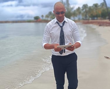 « Bruno Valery en réflexion stratégique, tablette en main, marchant sur une plage paradisiaque en Guadeloupe »