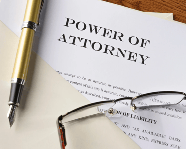 Power of attorney document with pen and glasses, symbolizing legal financial authority.