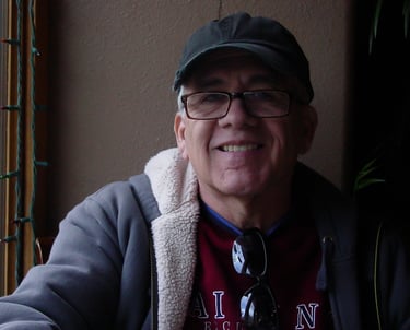 a man in a hat and glasses smiling