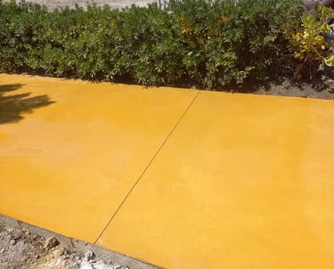 Hormigón pulido color amarillo para camino exterior.