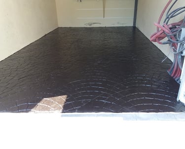 Superficie de hormigón impreso en color negro con diseño semicircular, ideal para parkings y zonas de almacenamiento."