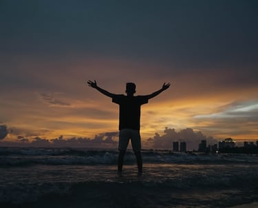 Restored vitality and freedom from chronic pain represented by a person raising hands in nature.