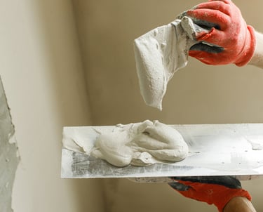 Handwerker beim Spachteln einer Wand im Rahmen von Malerarbeiten in Aachen