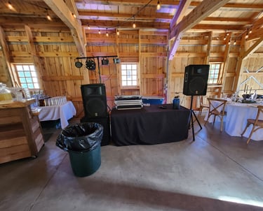 a dj booth with speakers and a table with a table cloth
