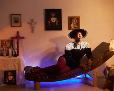 a black woman in a hat and a hat on a chaise lounge chair in a vintage house with a Catholic altar